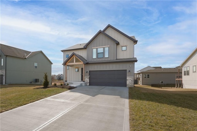 view of front of property with a garage, stone siding, board and batten siding, and a front yard