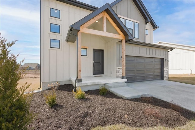 view of front facade featuring concrete driveway, stone siding, board and batten siding, and an attached garage