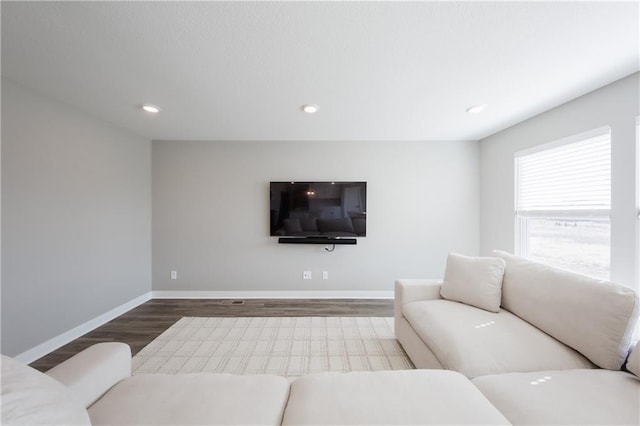 living area with recessed lighting, wood finished floors, and baseboards