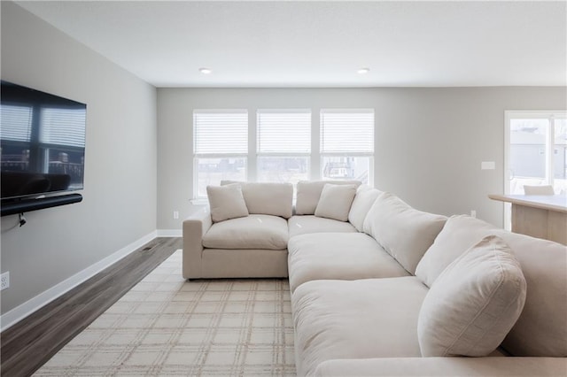 living room featuring light wood-type flooring, baseboards, a wealth of natural light, and recessed lighting