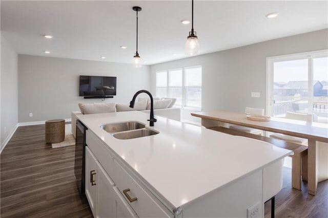 kitchen featuring white cabinetry, dark wood-type flooring, a sink, and open floor plan