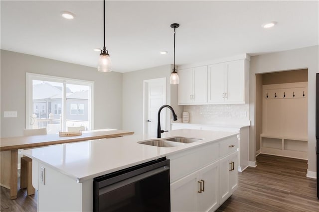 kitchen featuring white cabinets, light countertops, a sink, and dishwashing machine