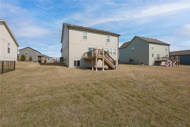 back of property with a yard, stairway, and a wooden deck