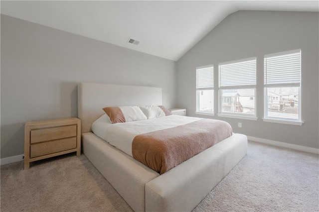 carpeted bedroom with visible vents, vaulted ceiling, and baseboards