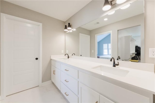 bathroom featuring double vanity, a sink, connected bathroom, and baseboards