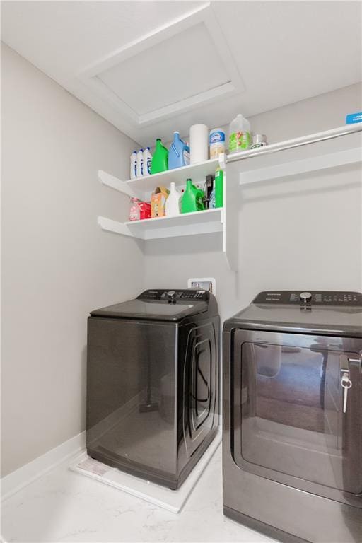 laundry room with marble finish floor, laundry area, washing machine and clothes dryer, and baseboards