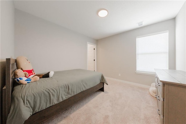 bedroom featuring baseboards, visible vents, and light colored carpet