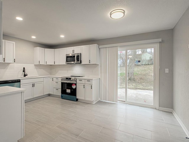 kitchen featuring white cabinetry, sink, backsplash, and stainless steel appliances