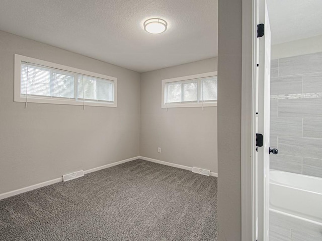 carpeted spare room with a textured ceiling