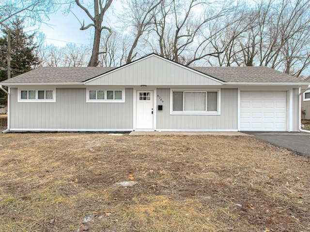 single story home featuring driveway, a garage, and roof with shingles