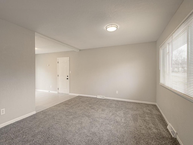 unfurnished room with visible vents, baseboards, and carpet