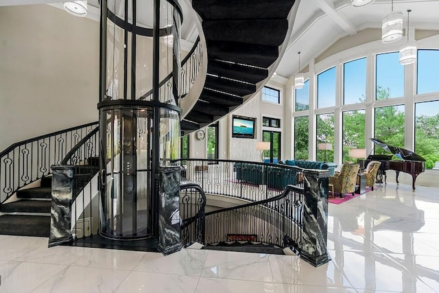 stairs with marble finish floor and high vaulted ceiling