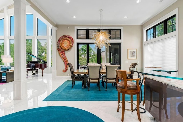 interior space with recessed lighting, baseboards, ornamental molding, an inviting chandelier, and ornate columns