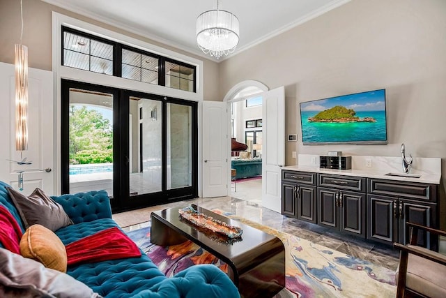 living area with ornamental molding and an inviting chandelier