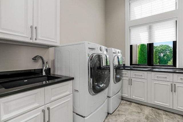 laundry room featuring cabinet space, washing machine and dryer, and a sink