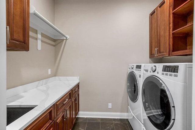 laundry room with a sink, cabinet space, baseboards, and washer and dryer