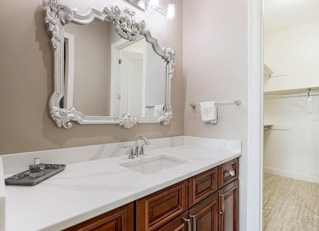 bathroom featuring a walk in closet and vanity