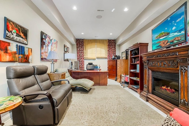 office space with visible vents, a glass covered fireplace, and recessed lighting