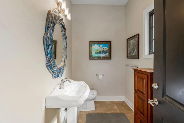 half bath with toilet and baseboards