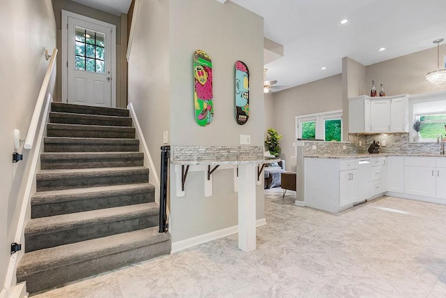 staircase featuring baseboards and recessed lighting