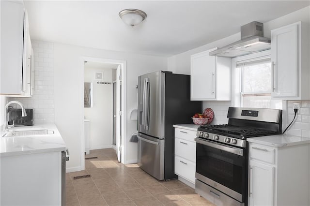 kitchen with stainless steel appliances, white cabinetry, sink, and wall chimney range hood