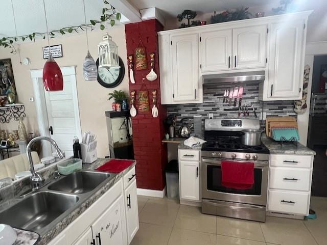 kitchen with light tile patterned flooring, sink, white cabinets, backsplash, and gas stove