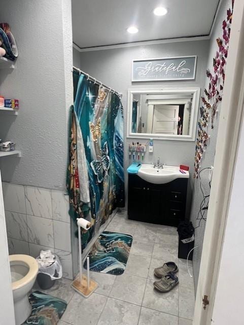 bathroom featuring tile walls, ornamental molding, vanity, a shower with shower curtain, and tile patterned flooring