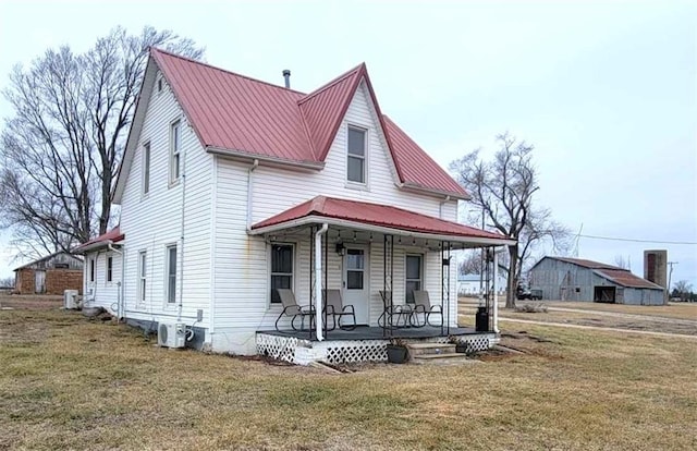 view of front facade with a porch, a front yard, and ac unit