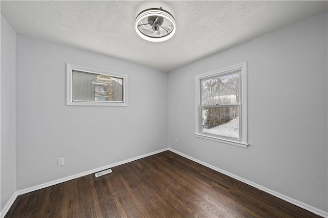 spare room with hardwood / wood-style flooring and a textured ceiling