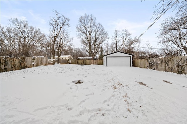 yard covered in snow with a garage and an outbuilding