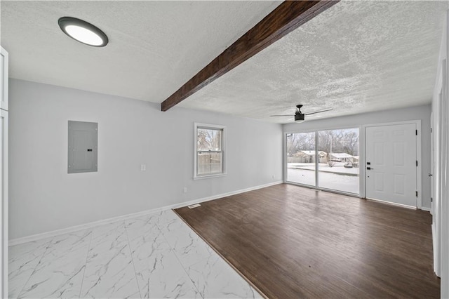 unfurnished living room featuring beamed ceiling, ceiling fan, electric panel, and a textured ceiling