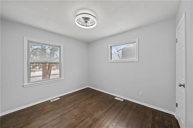 unfurnished room with hardwood / wood-style flooring, a wealth of natural light, and a textured ceiling