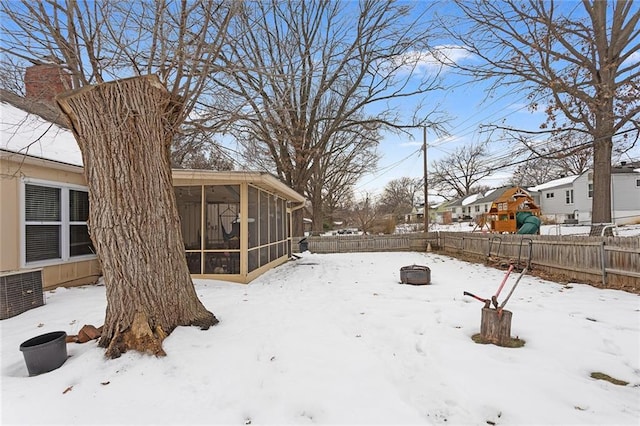 snowy yard featuring a sunroom