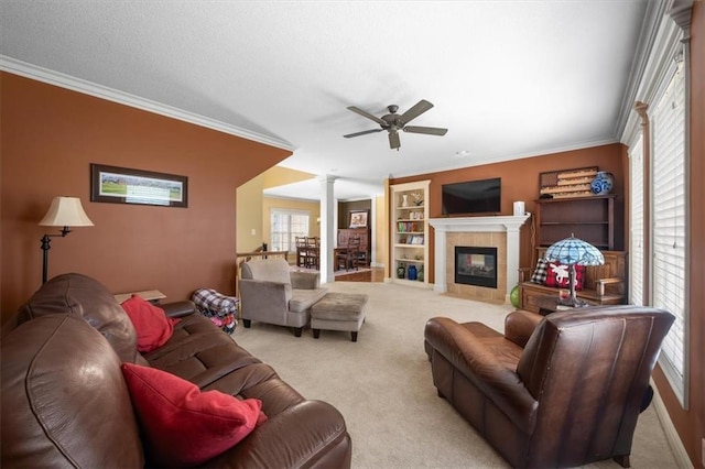 living area featuring ceiling fan, ornamental molding, ornate columns, and carpet floors