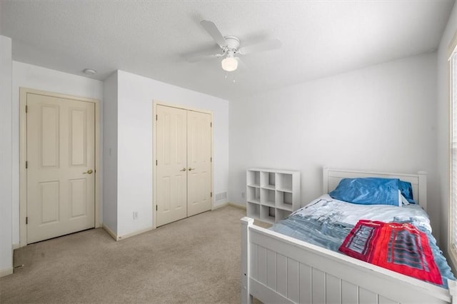 bedroom featuring visible vents, a ceiling fan, a textured ceiling, carpet floors, and baseboards