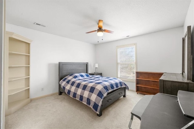 carpeted bedroom with a textured ceiling, baseboards, visible vents, and ceiling fan