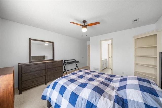 bedroom featuring visible vents, light carpet, ensuite bath, and a ceiling fan