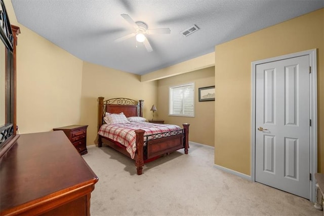 bedroom featuring visible vents, ceiling fan, baseboards, light carpet, and a textured ceiling