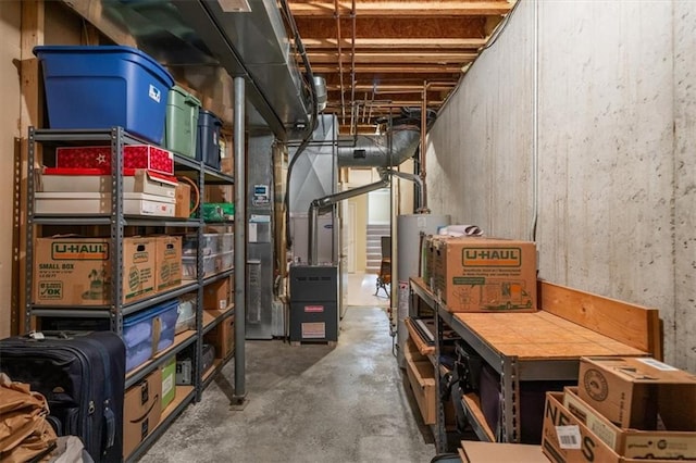 storage area featuring heating unit and gas water heater