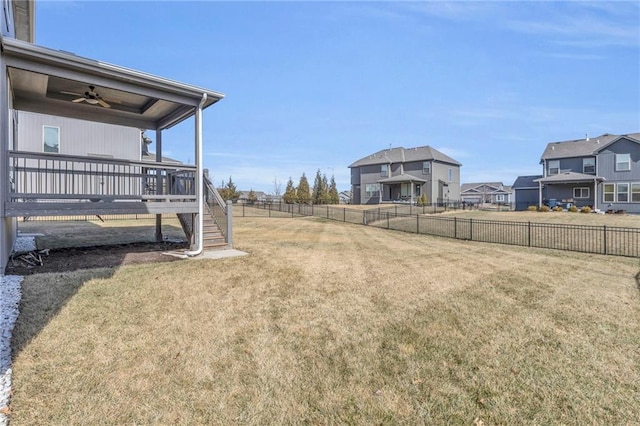 view of yard with ceiling fan, a fenced backyard, stairs, a wooden deck, and a residential view