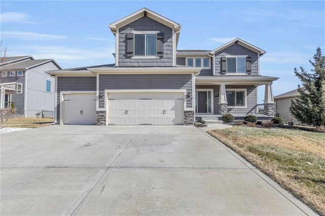 craftsman house with an attached garage, driveway, a porch, and a front yard