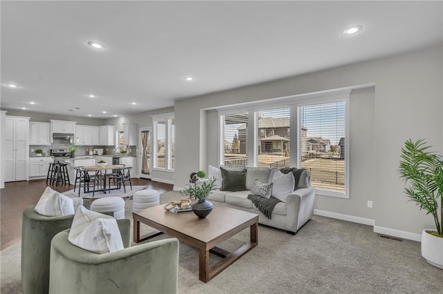 living room featuring baseboards, visible vents, and recessed lighting