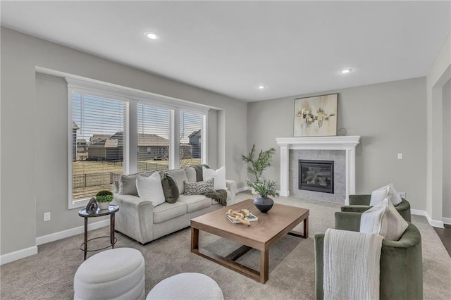 living area with a tile fireplace, baseboards, and recessed lighting