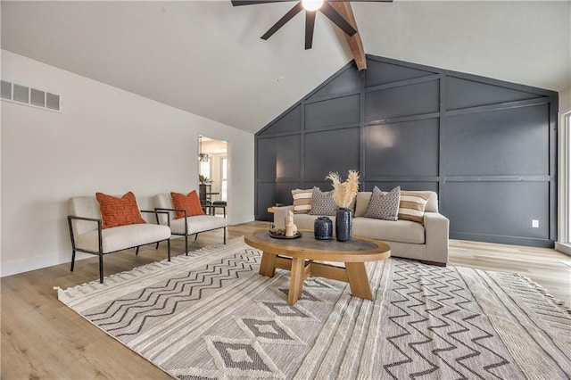 living room featuring ceiling fan, lofted ceiling with beams, and light hardwood / wood-style flooring