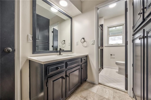 bathroom with vanity, tile patterned floors, a shower with door, and toilet