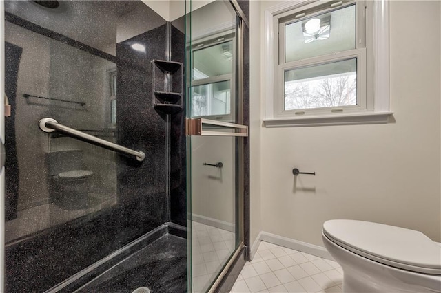 bathroom with tile patterned floors, toilet, and a shower with door