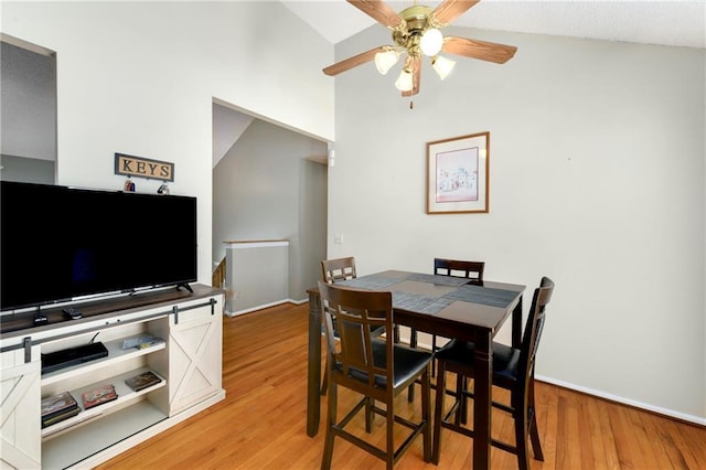 dining space featuring light wood-style floors, baseboards, and ceiling fan