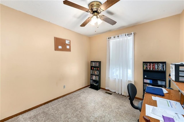 carpeted home office featuring a wealth of natural light, visible vents, a ceiling fan, and baseboards