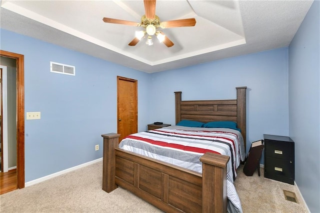 bedroom with baseboards, visible vents, a raised ceiling, and carpet floors