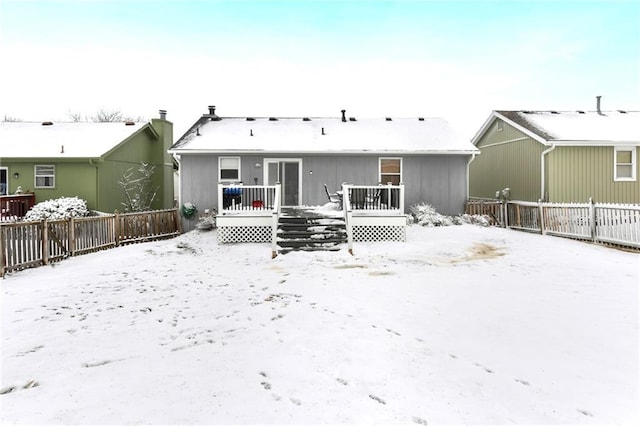 snow covered property featuring a deck and fence